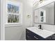 Charming half-bathroom featuring a modern vanity with sleek fixtures and a bright window at 7816 Wallace Ln, Charlotte, NC 28212