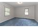 Empty bedroom with blue carpet, two windows, and light floral wallpaper at 783 Carpenter Ave, Mooresville, NC 28115