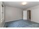 Empty bedroom with blue carpet and wallpaper, featuring two doors at 783 Carpenter Ave, Mooresville, NC 28115