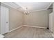 Neutral dining room with chandelier, light wood floors, and beige paint at 783 Carpenter Ave, Mooresville, NC 28115