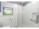 Clean shower featuring white tiles, a glass door, and accessible grab bars for safety at 783 Carpenter Ave, Mooresville, NC 28115