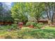 Well-maintained backyard featuring a brick wall, mature trees, and beautiful landscaping at 806 Sunnyside Ave, Charlotte, NC 28204