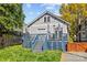 View of the backyard and blue deck of a grey two-story house with an adjacent gate at 806 Sunnyside Ave, Charlotte, NC 28204