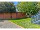Green backyard with brick wall, grass, and gravel extending from a deck staircase at 806 Sunnyside Ave, Charlotte, NC 28204