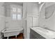 Bright bathroom with clawfoot tub, white marble sink with hardwood floors and natural light at 806 Sunnyside Ave, Charlotte, NC 28204
