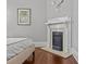 A tranquil bedroom featuring hardwood floors and a decorative white fireplace at 806 Sunnyside Ave, Charlotte, NC 28204