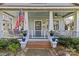 Inviting front porch with an American flag, white railings, and a brick pathway to the front door at 806 Sunnyside Ave, Charlotte, NC 28204