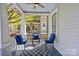 Cozy porch setup with seating, a ceiling fan, and stylish blue accents and a blue patterned rug at 806 Sunnyside Ave, Charlotte, NC 28204