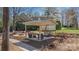 An outdoor living space is enhanced with a covered patio, stone fire pit, and well-manicured landscaping at 8194 Mallard Rd, Denver, NC 28037
