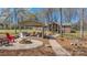 Spacious outdoor living area features a covered patio, fire pit, and lush landscaping in a serene backyard setting at 8194 Mallard Rd, Denver, NC 28037