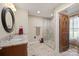 Well-lit bathroom featuring a tiled walk-in shower and granite countertop vanity with decorative mirror at 8194 Mallard Rd, Denver, NC 28037