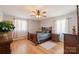 Bedroom featuring wood floors, a wooden bed frame, and natural light from two windows at 8194 Mallard Rd, Denver, NC 28037