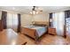 Comfortable bedroom featuring a wooden bed frame, hardwood floors, and natural light from two windows at 8194 Mallard Rd, Denver, NC 28037