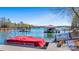A boat dock features a covered boat slip, a red pontoon boat, and stairs descending into the water at 8194 Mallard Rd, Denver, NC 28037