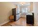 Compact kitchen featuring white cabinets, a stainless steel refrigerator, and hardwood floors at 8194 Mallard Rd, Denver, NC 28037