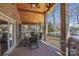 Covered outdoor living space with brick pillars, a ceiling fan, and a dining set overlooking the waterfront at 8194 Mallard Rd, Denver, NC 28037