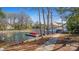 Picturesque waterfront view with docks, boat slips, and mature trees along the shoreline, accessible via a stone path at 8194 Mallard Rd, Denver, NC 28037