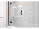 Bright bathroom featuring a glass-enclosed tub and shower, offering a clean and modern design at 9230 Avery Meadows Dr, Charlotte, NC 28216
