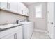 Laundry room with granite counters, window, storage, and modern washer and dryer at 9413 Liberty Hill Dr, Mint Hill, NC 28227
