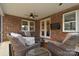 Relaxing outdoor patio with brick wall, ceiling fan, and comfortable wicker seating at 9413 Liberty Hill Dr, Mint Hill, NC 28227