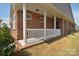 Inviting brick porch with white columns and railing, adding curb appeal at 9413 Liberty Hill Dr, Mint Hill, NC 28227