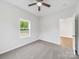 Bedroom with neutral walls and floors, ceiling fan, and door to hallway at 1067 Old Charlotte Rd, Concord, NC 28027