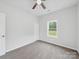 Bright bedroom featuring a ceiling fan, window, closet and neutral walls and flooring at 1067 Old Charlotte Rd, Concord, NC 28027