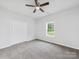 Cozy bedroom featuring neutral carpet, a ceiling fan, and a large window at 1067 Old Charlotte Rd, Concord, NC 28027