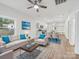 Bright, open-concept living space with modern furnishings, light hardwood flooring, and a ceiling fan at 1067 Old Charlotte Rd, Concord, NC 28027