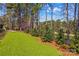 Lush backyard with manicured lawn, mature trees, and a view of the adjacent golf course at 115 Brawley Harbor Pl, Mooresville, NC 28117