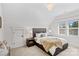 Bright bedroom with a queen bed, two windows, dark wood nightstands, and an elegant chandelier at 115 Brawley Harbor Pl, Mooresville, NC 28117