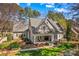 Aerial view of a charming home with a beautifully landscaped yard surrounded by mature trees at 115 Brawley Harbor Pl, Mooresville, NC 28117