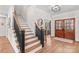 Inviting foyer with hardwood floors, elegant staircase, and a glimpse into a sitting room at 115 Brawley Harbor Pl, Mooresville, NC 28117