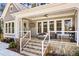 Inviting front porch with stone stairs, cozy seating, and a ceiling fan, perfect for relaxing at 115 Brawley Harbor Pl, Mooresville, NC 28117