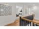Bright hallway features hardwood floors, white walls adorned with pictures, and a view into the living area at 115 Brawley Harbor Pl, Mooresville, NC 28117