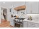 Gourmet kitchen features stainless appliances, custom cabinets, range hood, and marble backsplash at 115 Brawley Harbor Pl, Mooresville, NC 28117