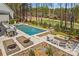Stunning pool area featuring lounge chairs, a fire pit, and lush landscaping, ideal for entertaining at 115 Brawley Harbor Pl, Mooresville, NC 28117