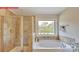 Bathroom featuring a tiled shower, soaking tub, and window with outdoor view at 116 Fordingbridge Ln, Mooresville, NC 28115