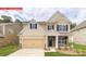Charming two-story home featuring a welcoming front porch, manicured lawn, and attached two-car garage at 116 Fordingbridge Ln, Mooresville, NC 28115