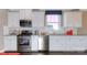 Well-lit kitchen featuring white cabinets, stainless steel appliances, and ample counter space at 116 Fordingbridge Ln, Mooresville, NC 28115