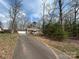 A cozy brick and siding home has a long driveway surrounded by mature trees at 1222 Hillsboro Ave, Hickory, NC 28602
