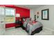 This bedroom features a red accent wall, a metal-framed bed, and stylish decor creating a unique and energetic space at 124 Fordingbridge Ln, Mooresville, NC 28115