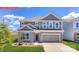 Charming two-story home with gray siding, stone accents, and well-manicured lawn, providing inviting curb appeal at 124 Fordingbridge Ln, Mooresville, NC 28115