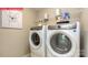 The laundry room features a side-by-side washer and dryer, overhead shelving and neutral walls at 124 Fordingbridge Ln, Mooresville, NC 28115