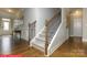 Elegant staircase with hardwood floors, decorative wainscoting, and iron balusters leading to the upper level at 124 Fordingbridge Ln, Mooresville, NC 28115