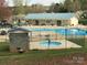 Beautiful community pool and clubhouse with ample seating, hot tub, and blue roof at 128 Twin Bluff Trl # C52, Mount Gilead, NC 27306