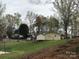 Exterior view of the property with mature trees, a grassy lawn and community buildings at 128 Twin Bluff Trl # C52, Mount Gilead, NC 27306