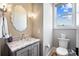 Stylish powder room with a marble countertop and decorative mirror, adding a touch of luxury at 1311 Sunnys Halo Ln, Waxhaw, NC 28173