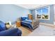 Bright blue bedroom with natural light, a bookcase and a comfortable seating area at 1311 Sunnys Halo Ln, Waxhaw, NC 28173