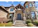 Grand front entrance showcasing stone steps, a wooden portico, and custom iron doors at 1311 Sunnys Halo Ln, Waxhaw, NC 28173